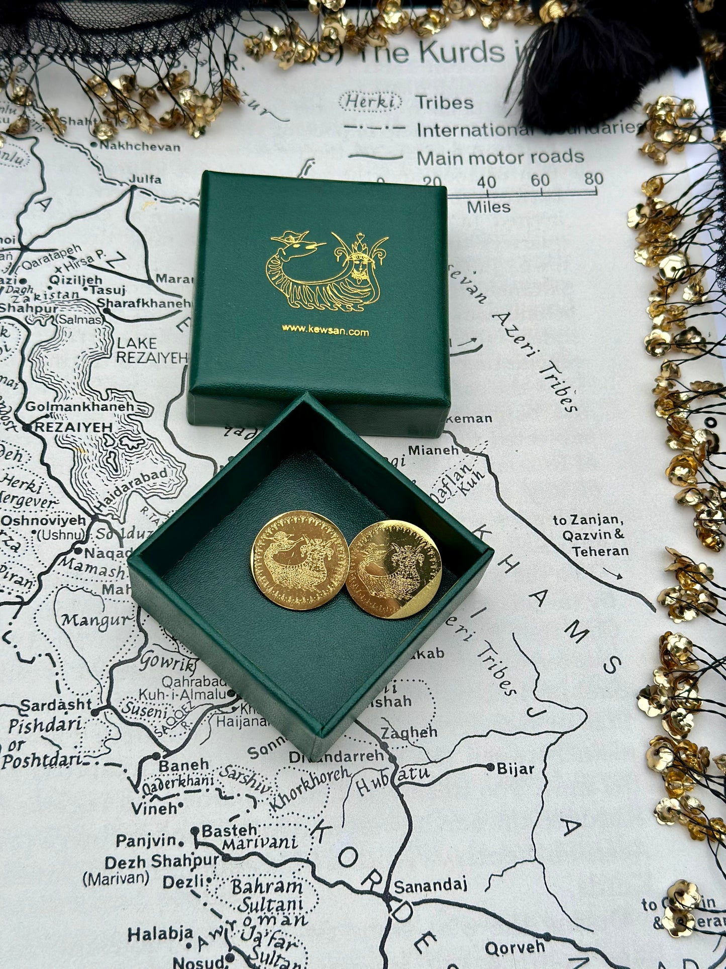 Golden Shahmaran Brooch with intricate laser-etched design, inspired by Kurdish heritage, displayed elegantly.