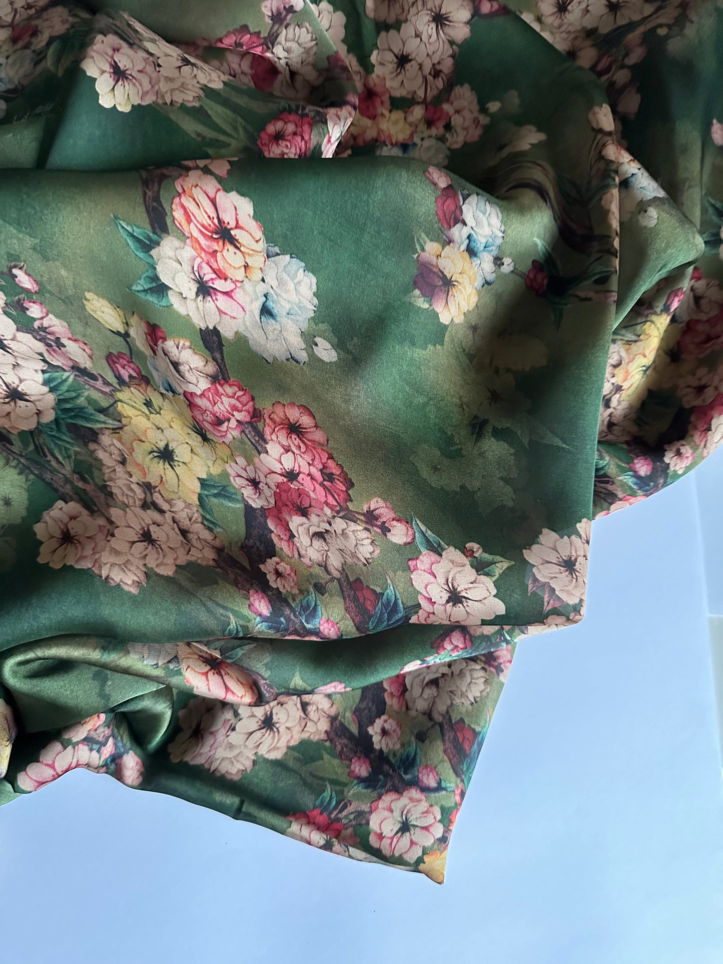 Green floral silk satin fabric with high-quality material perfect for wedding dresses and elegant evening gowns.