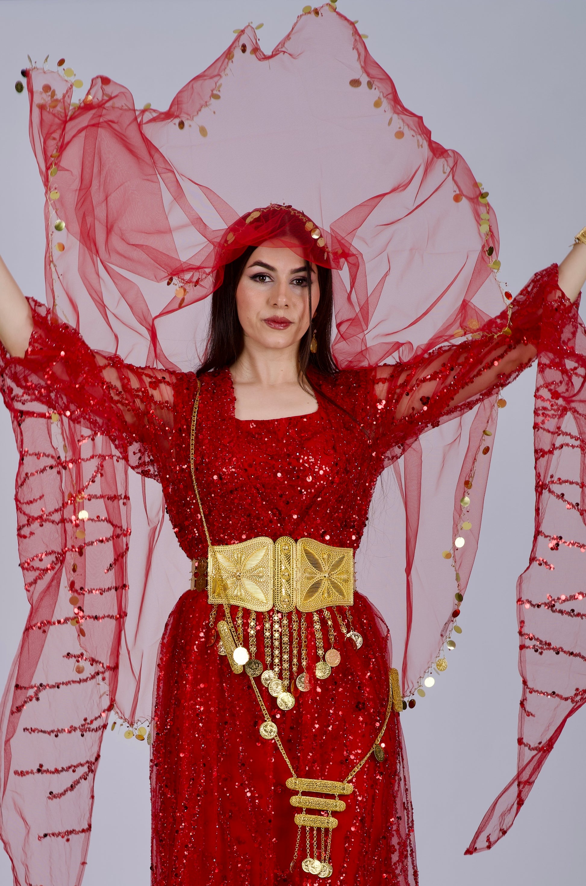  Model wearing the red Kurdish dress in a Henna night setting, celebrating Kurdish culture and tradition.