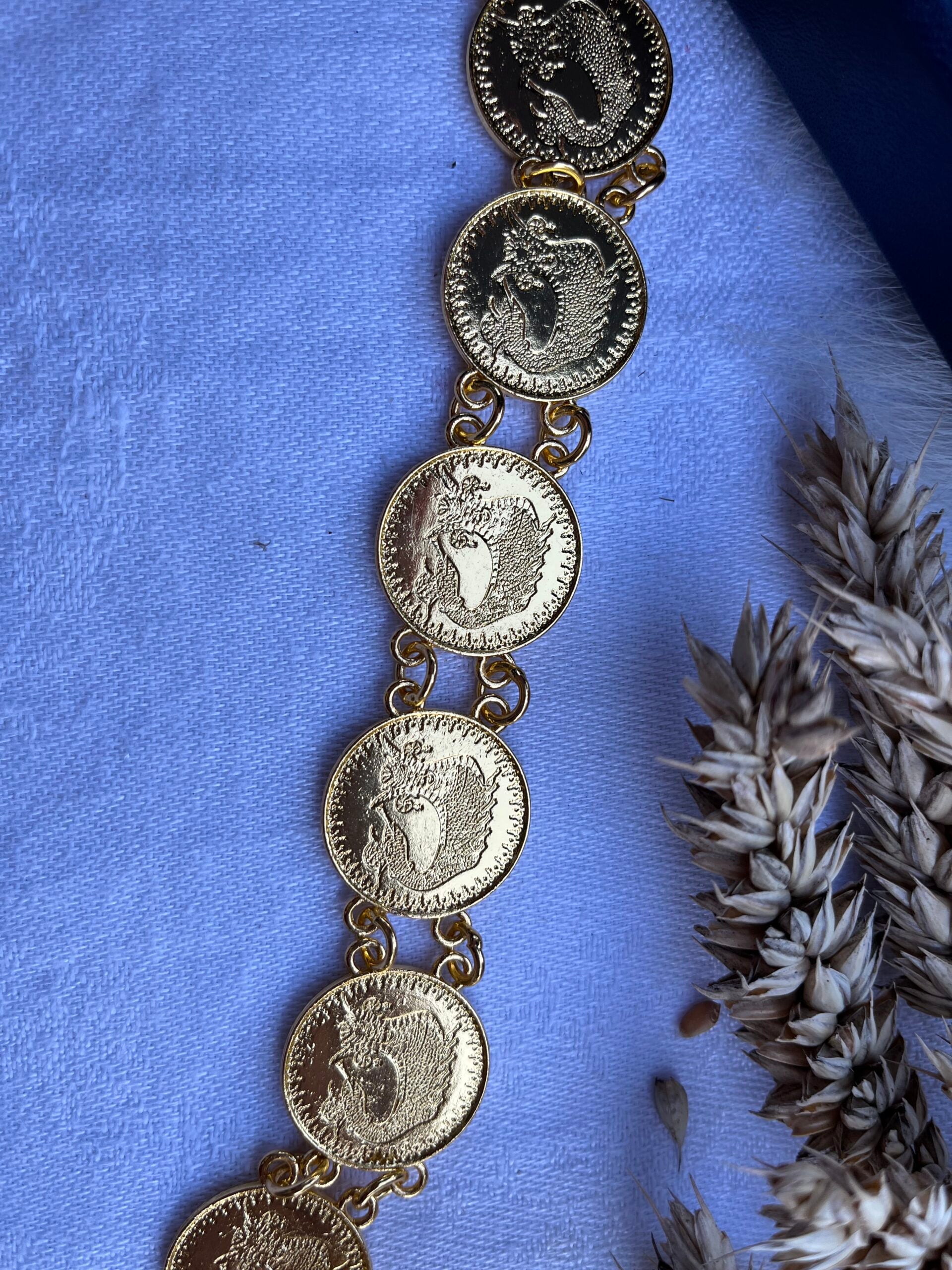 Detailed close-up of the Shamaran Belt with welded chain links and gold-plated coins.