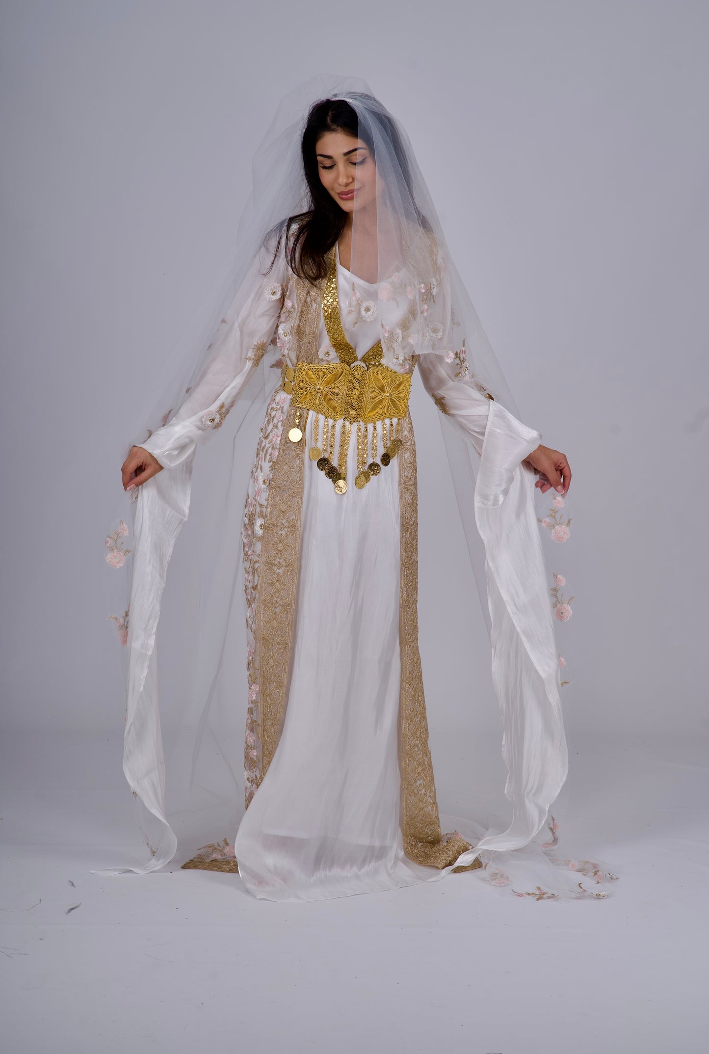 Close-up of the Kawa with 3D floral embroidery, crystals, and golden details on the white Kurdish dress.